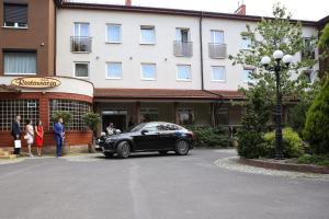 DziałoszynRestauracja Hotel VIP的一辆黑色汽车停在一栋建筑物前