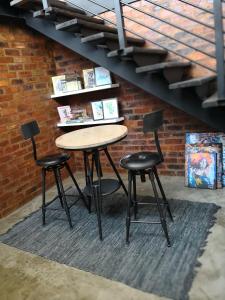 a table and two chairs in front of a brick wall at Entire Industrial-Style Loft in Maboneng in Johannesburg