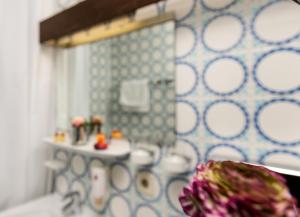 ein Bad mit einem Waschbecken und einem Spiegel in der Unterkunft Hotel Alpenhof Postillion in Kochel