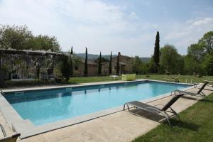 einen Pool mit zwei Liegestühlen im Hof in der Unterkunft AGRITURISMO Casale Il Caggio in Ciggiano