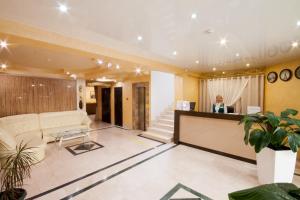 a woman standing at the reception desk of a hotel lobby at Экодом Сочи in Sochi