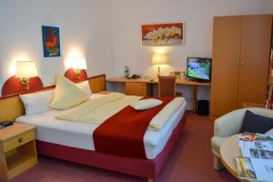 Habitación de hotel con cama y silla en HANSA Hotel, en Mendig