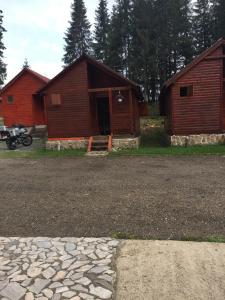 a couple of barns with a motorcycle parked in front at Popas Turistic Padis in Padis