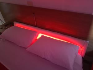 un letto con una luce rossa sopra di Hotel Houston Livorno - Struttura Esclusivamente Turistica - Not for Business or Workers a Livorno