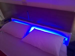 a bed with a blue light on top of it at Hotel Houston Livorno - Struttura Esclusivamente Turistica - Not for Business or Workers in Livorno