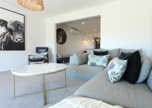 ein Wohnzimmer mit einem Sofa und einem Tisch in der Unterkunft 2 - Handsome and Sunkissed on the Doorstep to Wanaka in Wanaka