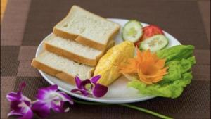 a plate with sandwiches and vegetables on a table at Trang Toan Hotel in Cat Ba