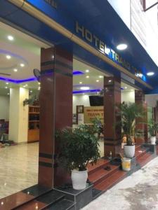 a hotel entrance with potted plants in a building at Trang Toan Hotel in Cat Ba