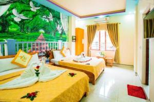 a hotel room with two beds and a painting on the wall at Trang Toan Hotel in Cat Ba