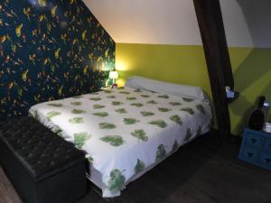 ein Schlafzimmer mit einem großen Bett und einer grünen Wand in der Unterkunft L'écrin du Val de Sambre in Maubeuge