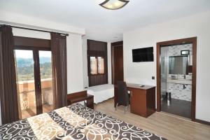 a hotel room with a bed, chair, table and window at Hotel Ciudad de Plasencia in Plasencia