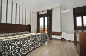 
a bedroom with a large bed and a large window at Hotel Ciudad de Plasencia in Plasencia
