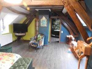 ein Wohnzimmer mit einem Sofa und einem TV in der Unterkunft L'écrin du Val de Sambre in Maubeuge