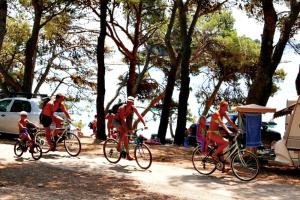 a group of people riding bikes down a dirt road at Camping Kozarica Mobile Homes in Pakoštane