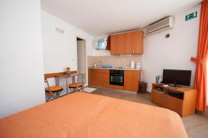 a bedroom with a bed and a small kitchen at Studio and Room Lena in Dubrovnik