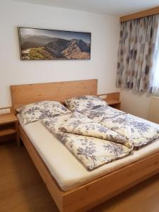 a bedroom with a bed with a wooden headboard at Ferienwohnung Fringer in Obtarrenz