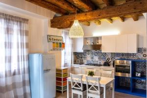 a kitchen with a refrigerator and a table with chairs at La Casa di Bassano in Bassano del Grappa