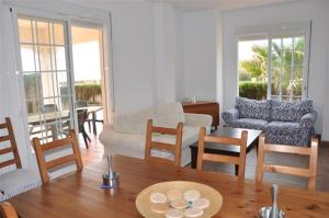 ein Wohnzimmer mit einem Sofa, einem Tisch und Stühlen in der Unterkunft Villa Canela with Heated Pool, Piscina Climatizada in Isla Canela