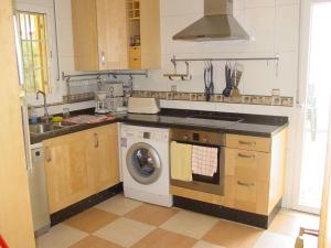 a kitchen with a sink and a washing machine at Villa Mar - now with HEATED POOL! in Isla Canela