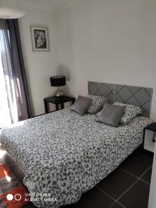 appartement marseille velodrome في مارسيليا: غرفة نوم بسرير لحاف اسود وبيض