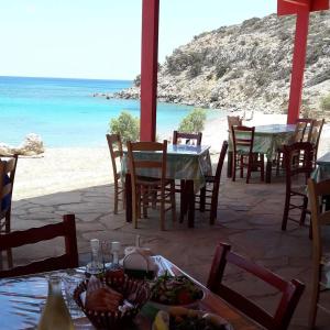 een restaurant met een tafel en stoelen en het strand bij Akrogiali in Gavdos