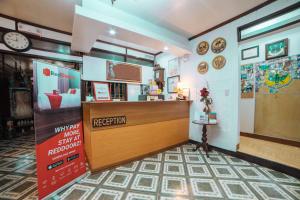 a waiting room with a reception counter and clocks on the wall at RedDoorz at La Casa Guesthouse former RedDoorz at Tamarind Street Angeles City in Angeles
