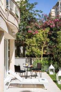 a patio area with chairs, a table, and a patio umbrella at White Villa Tel Aviv Hotel in Tel Aviv