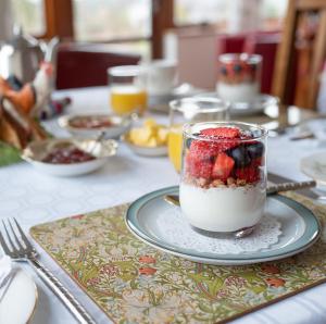 un tavolo con ciotola di yogurt e frutta di BallyCairn House a Larne