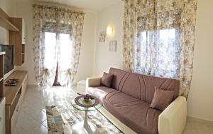 a living room with a couch and two windows at Casa Palanca Lake view apartment by Gardadomusmea in Tremosine Sul Garda