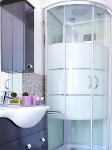 bagno bianco con lavandino e specchio di Villa Luisa Appartamenti Vacanze a Caiolo
