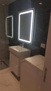 ein Bad mit einem Waschbecken und einem Fenster in der Unterkunft Delfin Apartments in Sarandë