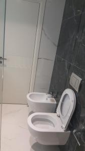 ein Badezimmer mit einem weißen WC und einem Waschbecken in der Unterkunft Delfin Apartments in Sarandë