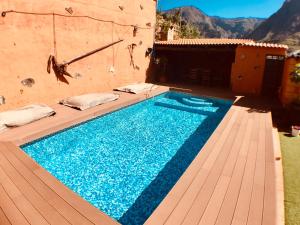 a swimming pool on a wooden deck with a house at La Casa Del Valle in Agaete