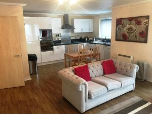 a living room with a couch and a kitchen at Contemporary Apartments, Balcony & Parking in Basingstoke