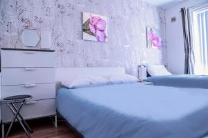 ベルファストにあるCentral City - Parking - Great Location -4 Bedsのピンクの花の壁のベッドルーム1室(ベッド2台付)