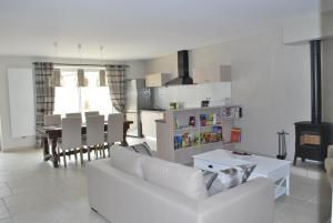 a living room with a white couch and a table at Chambres d'hôtes La Leva in Villette-dʼAnthon