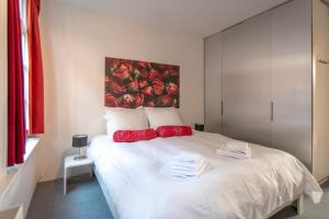 アムステルダムにあるHere's Lucyのベッドルーム(白いベッド、赤い枕付)