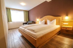 a bedroom with a large bed and a window at Chalets Hotter Ferienhaus mit E-Ladestation in Zell am Ziller