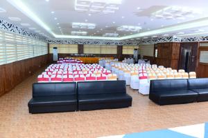 a banquet hall with red and white tables and chairs at BROAD BEAN KANNUR in Kannur