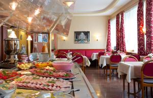 a dining room with a table with food on it at Hotel Carmen in Munich