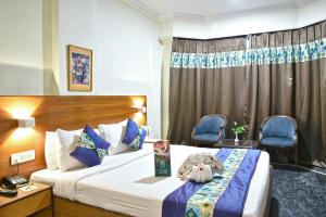 a hotel room with a bed and two chairs at Quality Inn Residency in Hyderabad +113 photos