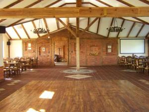 a large room with tables and chairs and a screen at Dworek u Leszczyńskich in Gościszewo