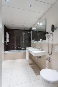 Hotel Euler Basel في بازل: حمام مع حوض وحوض استحمام ومرحاض
