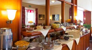 una linea di buffet con molti piatti e ciotole di cibo di Hotel Carmen a Monaco