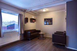 a waiting room with a couch and a window at Coal Miners’ Cabins in Longyearbyen