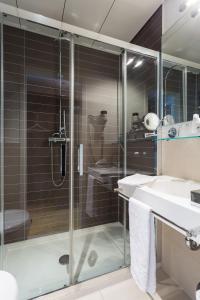 a bathroom with a glass shower and a sink at Hotel Euler Basel in Basel