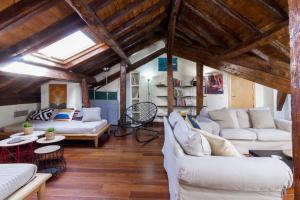マドリードにあるApartamento rústico de lujoの白いソファと木製の天井が備わるリビングルーム