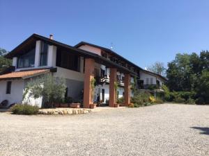 a house with a gravel driveway in front of it at Agriturismo Fano's Farm in Suno