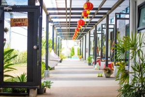 a corridor of a greenhouse with plants and lanterns at ChillHub Hostel Phuket in Bang Tao Beach