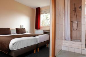 1 dormitorio con cama y ducha en La Clef des Champs - Proche Colmar, en Biesheim